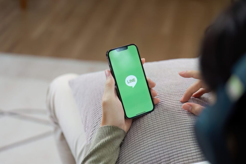 man hand holding screen shot of LINE application