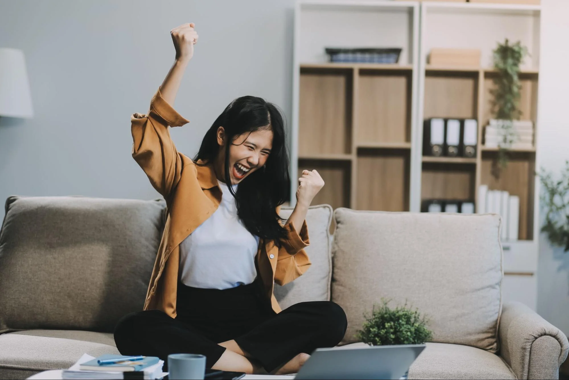 Young Chinese consumer celebrating while watching content on a laptop, representing audience engagement with viral Chinese social media campaigns.