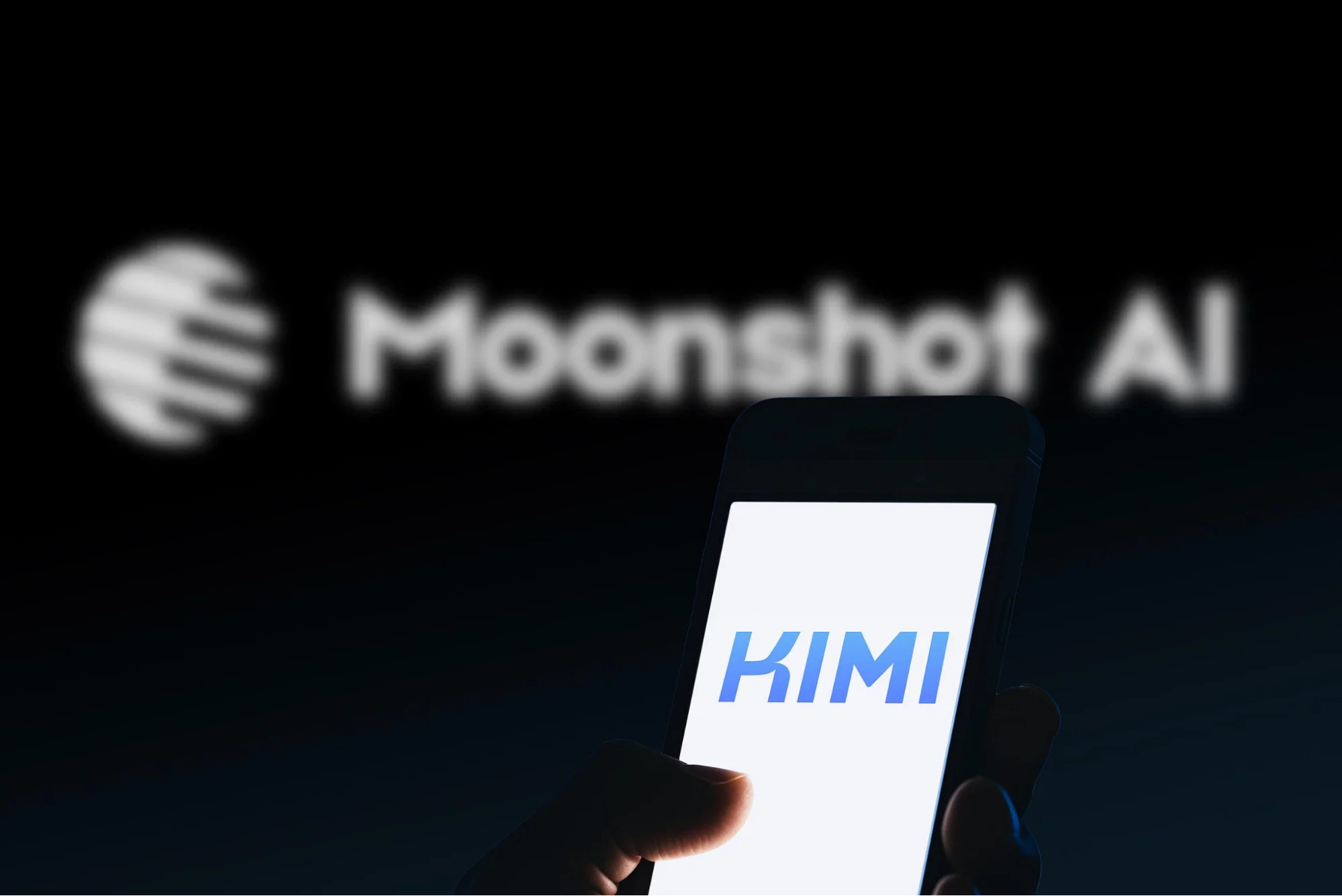 Smartphone displaying Kimi AI app with Moonshot AI branding blurred in the background