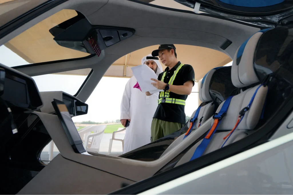 XPeng flying car cockpit interior showing passenger seats, control interface, and engineers reviewing flight system setup