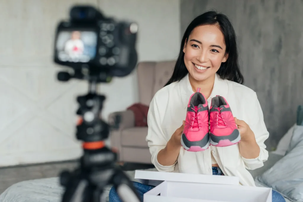 Content creator filming product review, holding sneakers in front of camera for influencer marketing content