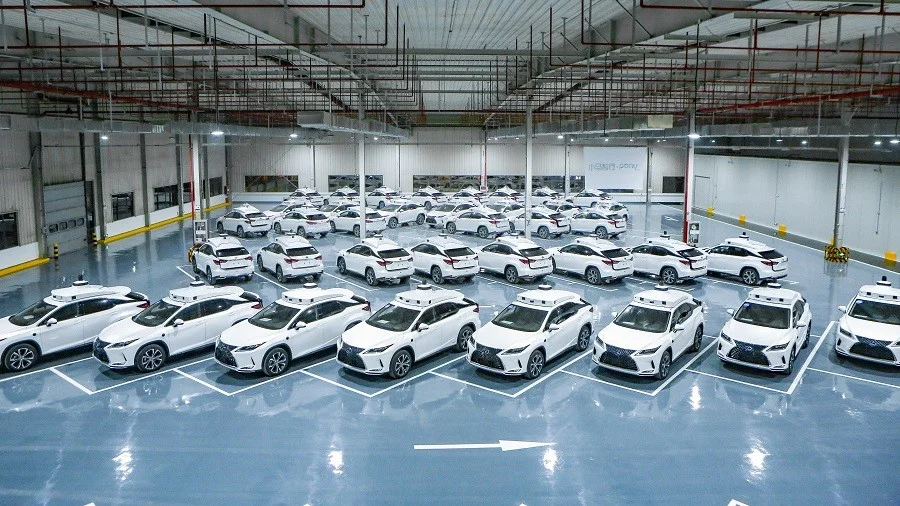 Large Pony AI robotaxi fleet parked inside facility showing scalable autonomous vehicle operations