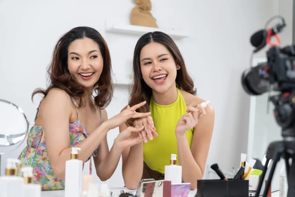 Beauty influencers recording skincare tutorial together in front of camera for social media audience