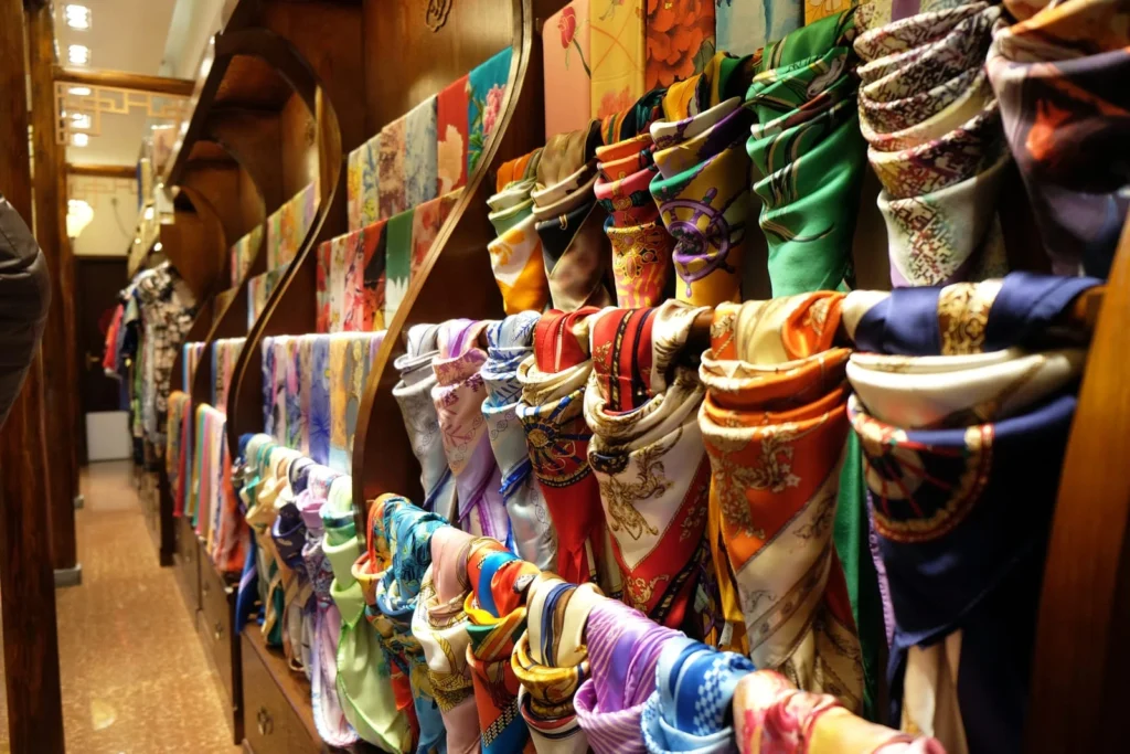 Display of colorful silk scarves with traditional patterns representing heritage craftsmanship and cultural fashion consumption in China