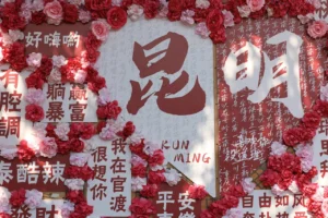 Qixi Festival themed wall decorated with red flowers and Chinese characters expressing love and emotions during Chinese Valentine’s Day celebrations