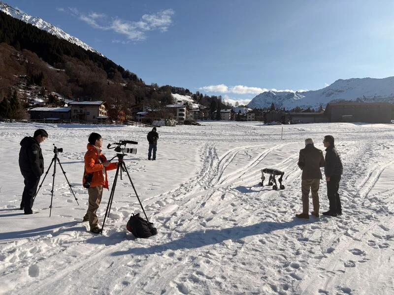 Quadruped robot tested in snowy terrain with team filming real-world performance
