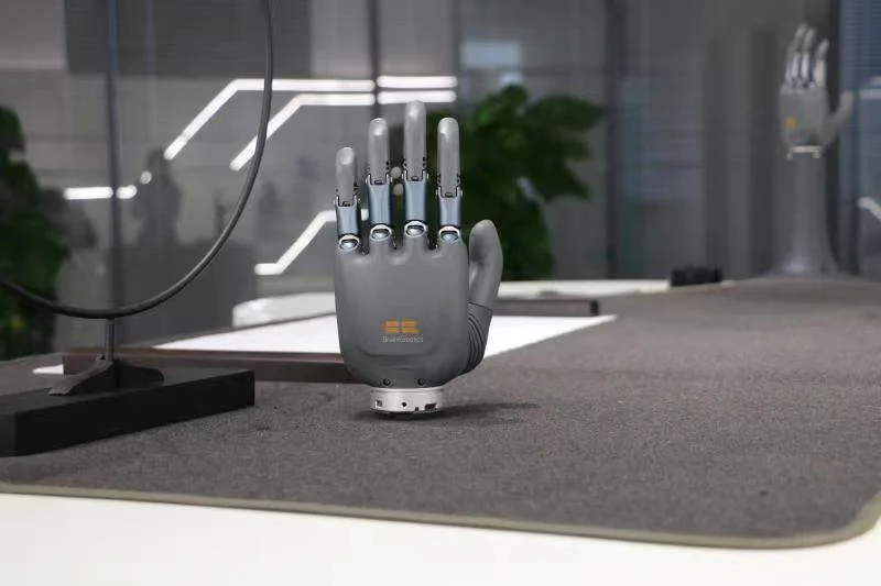 Robotic prosthetic hands demonstrating precision grip by holding a pen