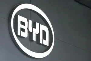 Illuminated BYD company logo mounted on a modern corporate building exterior.