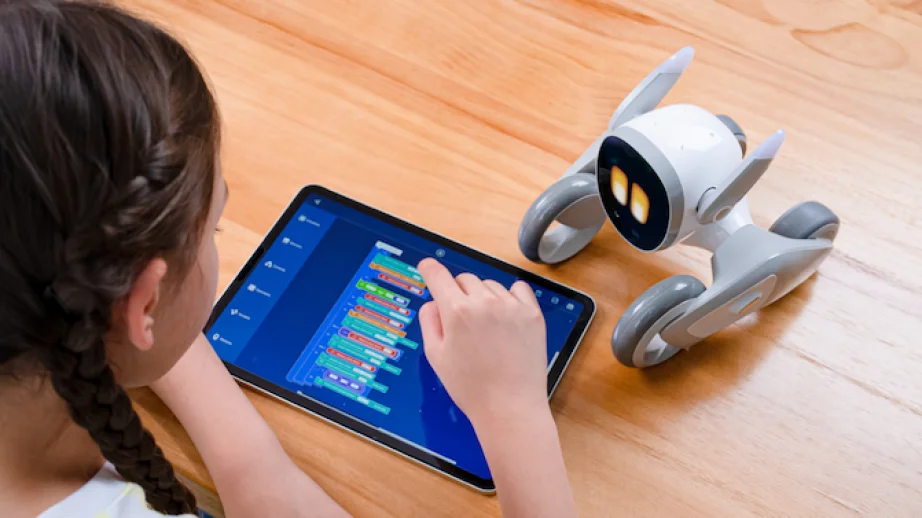 Child interacts with a Loona AI learning robot.