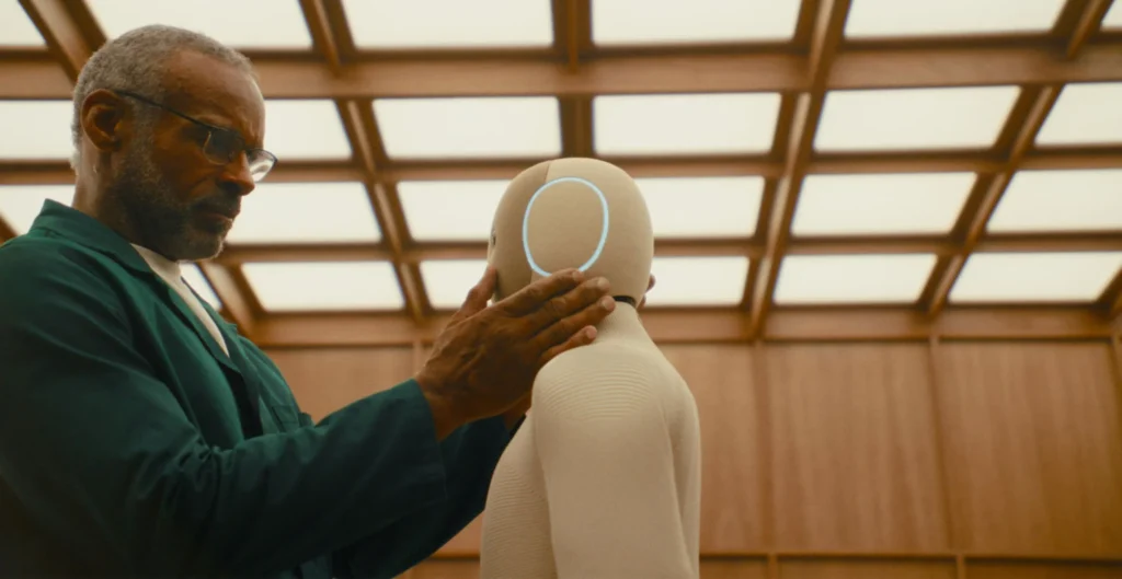 Engineer interacting with the NEO home robot during testing inside a research facility