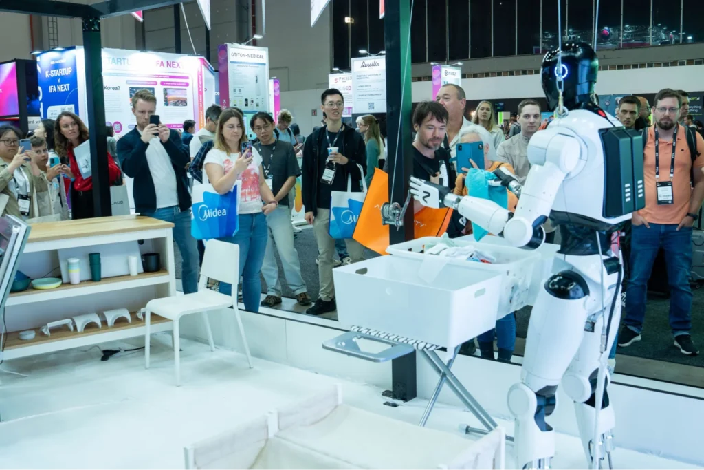 NEURA humanoid robot demonstrating a household task in front of visitors at a technology exhibition.