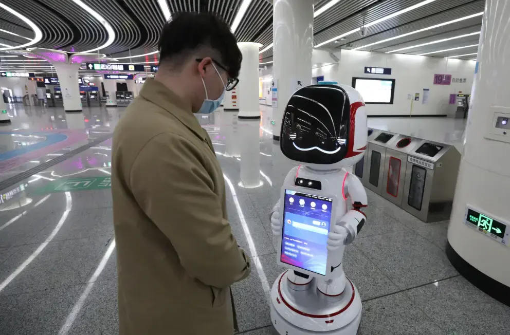 RaaS robot assisting passengers in a public transport setting.