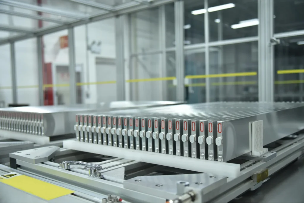Close-up of battery cells aligned in a manufacturing system inside a factory