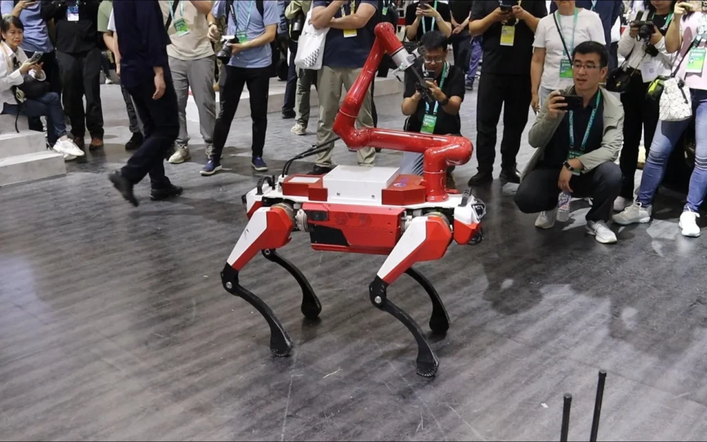 Quadruped robot demonstrated at technology exhibition with audience observing and recording
