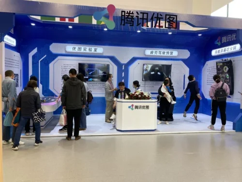 Visitors exploring Tencent AI exhibition booth with interactive displays and product demonstrations