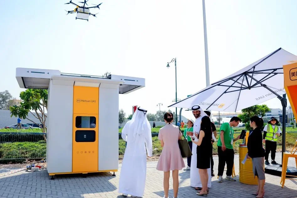 Meituan drone station with users collecting deliveries showing real-world deployment of autonomous delivery infrastructure