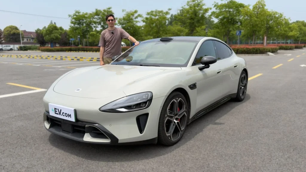 Reviewer standing beside Xiaomi SU7 electric sedan