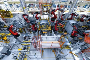 Robotic arms assembling vehicles in an automated automotive factory