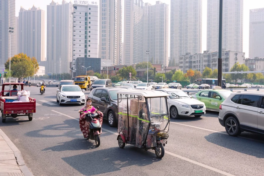 Busy Chinese city road with cars and scooters