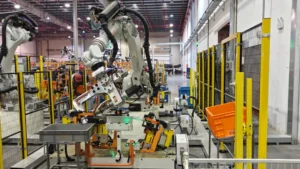 White industrial robotic arm operating inside safety-caged manufacturing cell