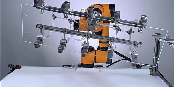 Collaborative robotic arm mounted on flexible frame working in automated testing environment.