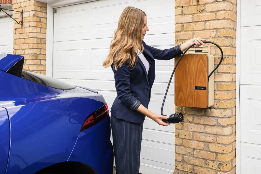 Woman plugging an electric car into a home charging unit.