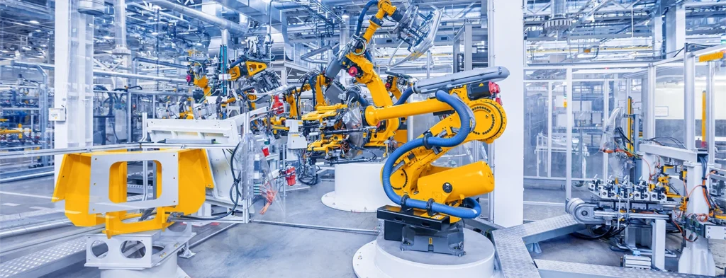 Industrial robot arms assembling vehicles inside a modern car manufacturing plant.