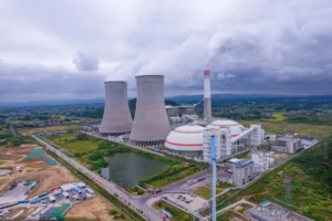 Large cooling towers and power station under cloudy sky