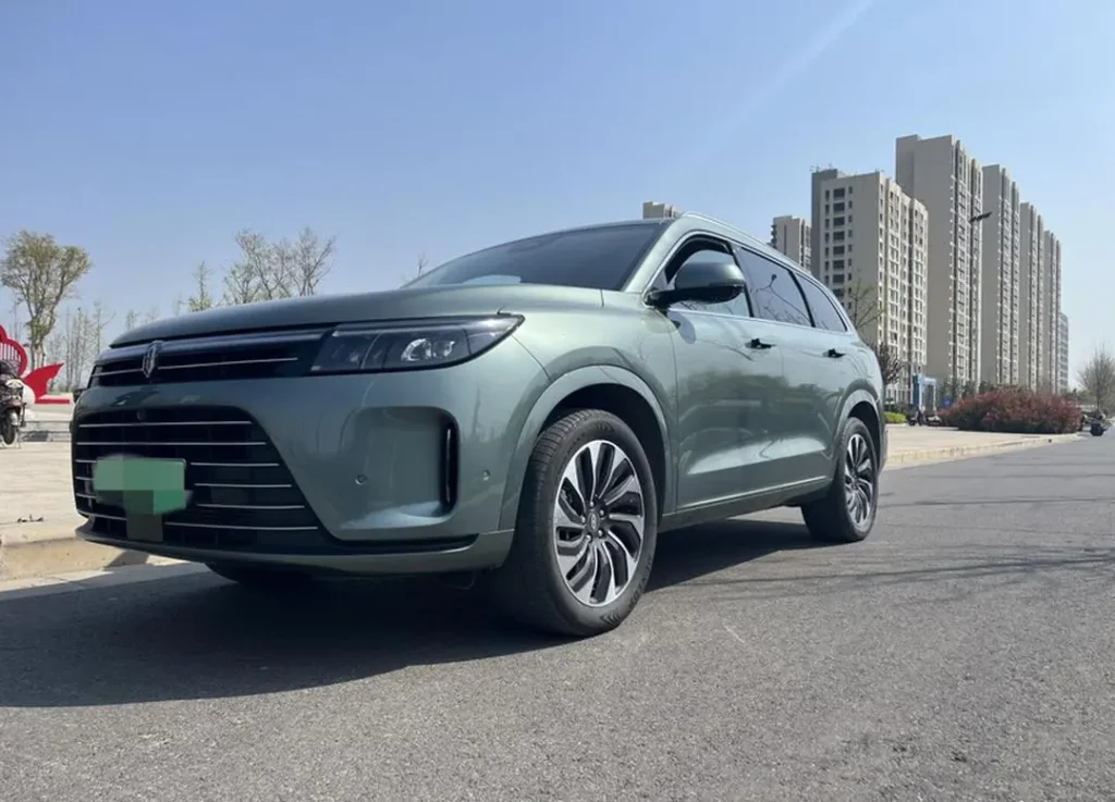 Green SERES SUV parked on a street in an urban residential area