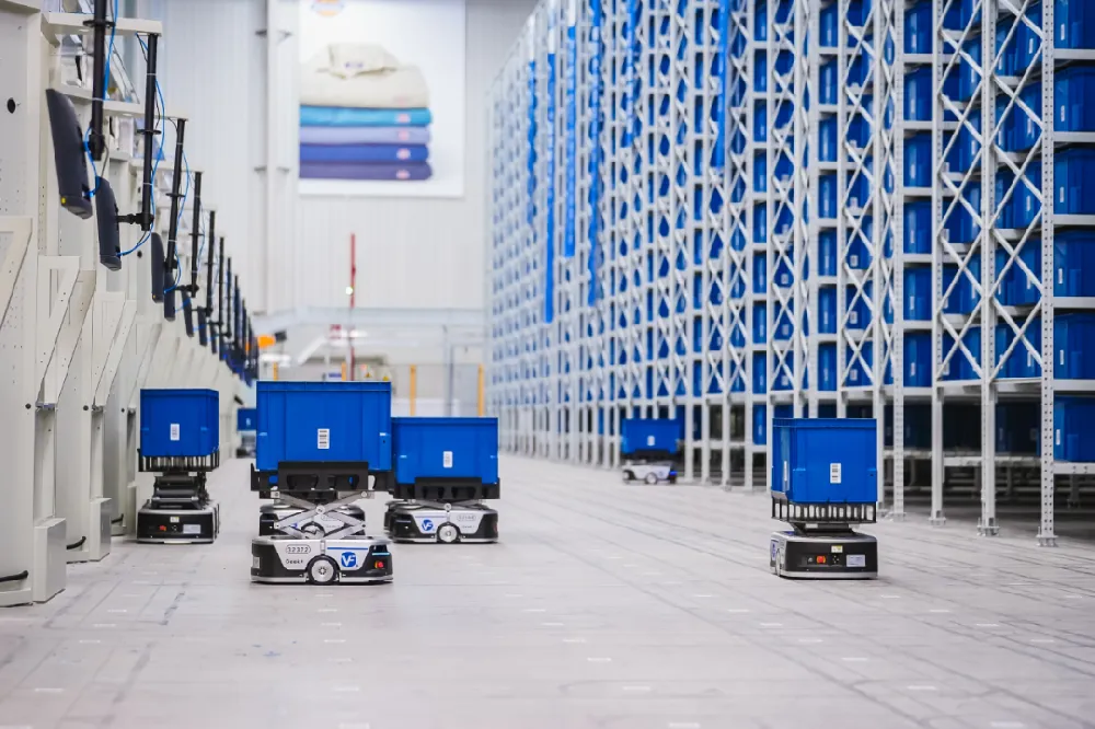 AMR robots carrying blue bins in automated storage