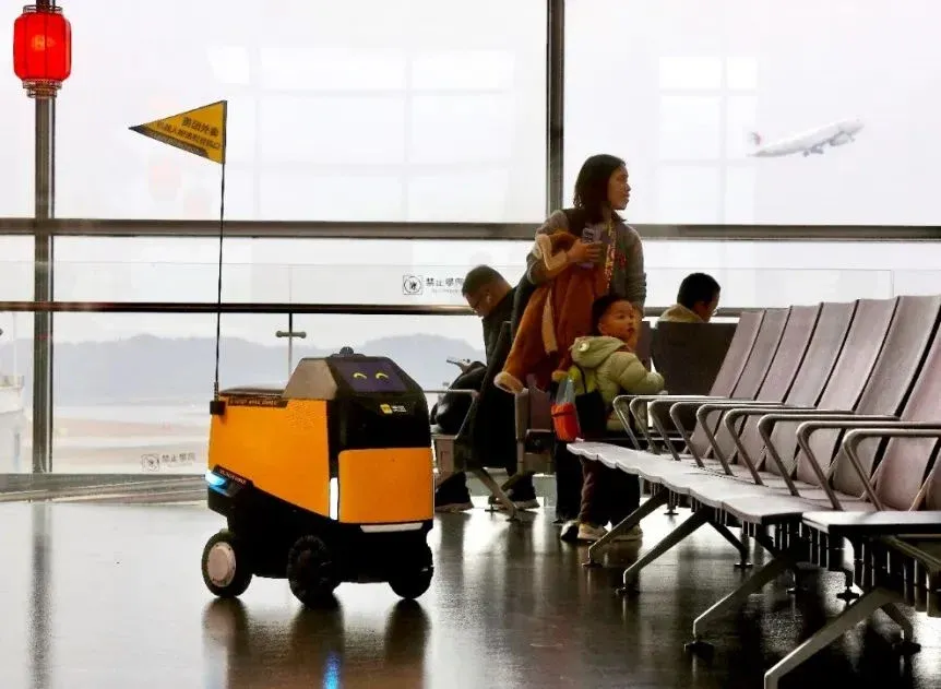 Yellow delivery robot in airport lounge