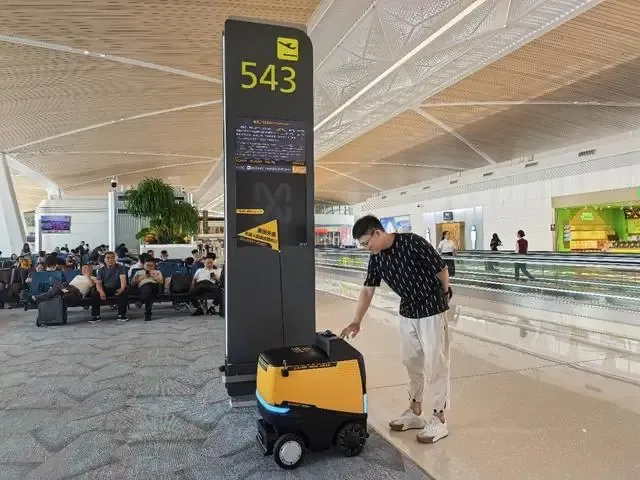 Man using delivery robot at airport gate