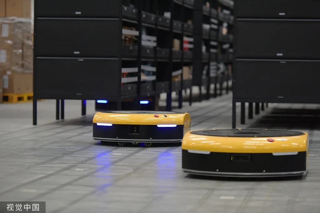 Yellow warehouse robots moving between storage racks