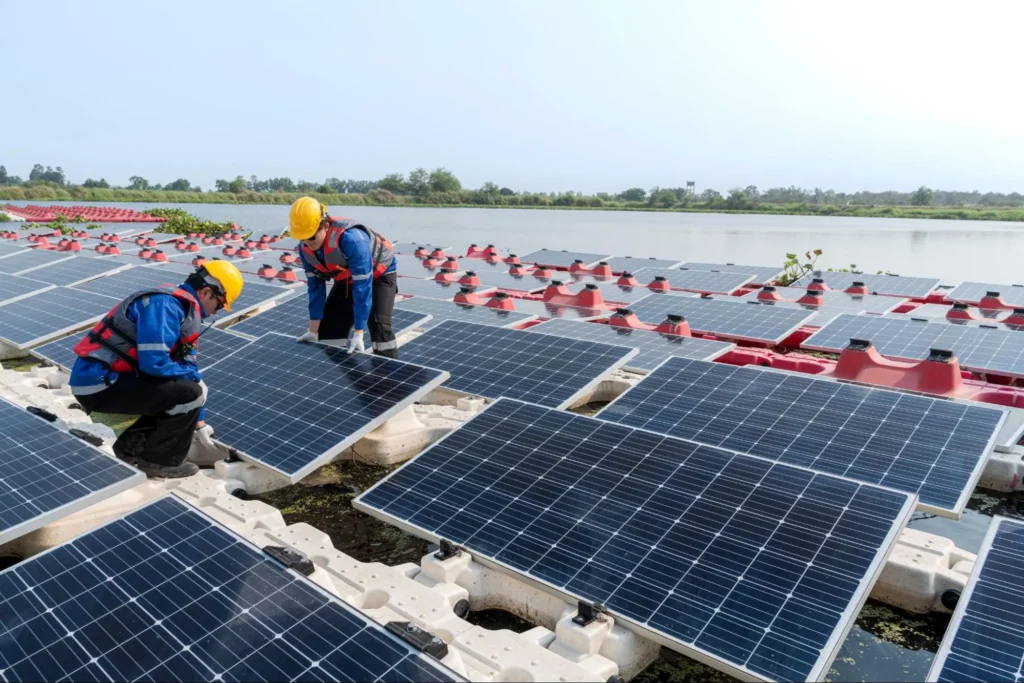Workers installing floating solar panels on water