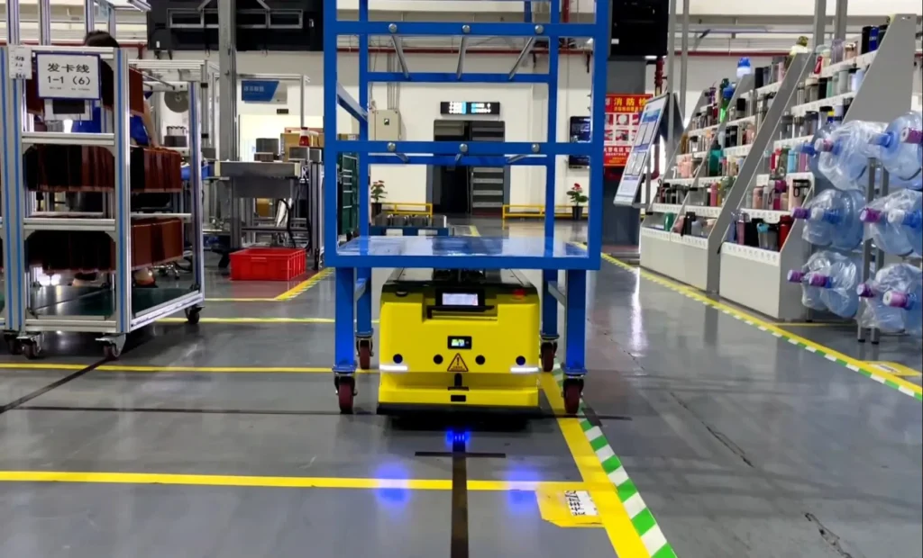 Yellow AGV moving a cart on factory guide path