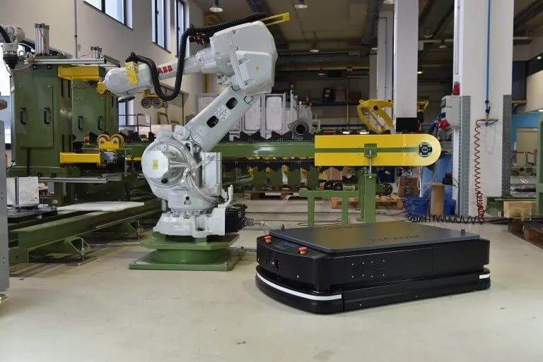 Mobile robot working beside an industrial robotic arm