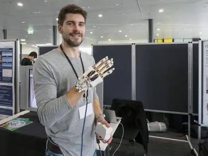 Man demonstrating robotic hand device at tech event