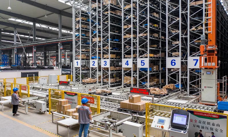 Automated warehouse with tall storage racks and conveyors