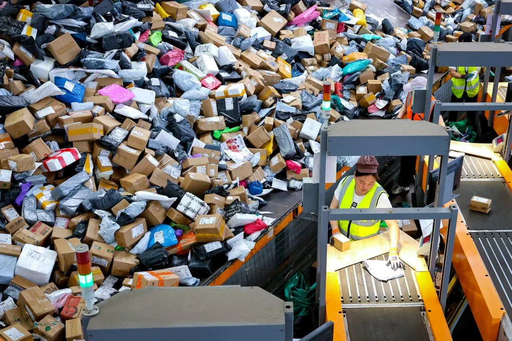 Workers sort parcels on an automated conveyor line at a Chinese logistics hub during a peak online shopping period.