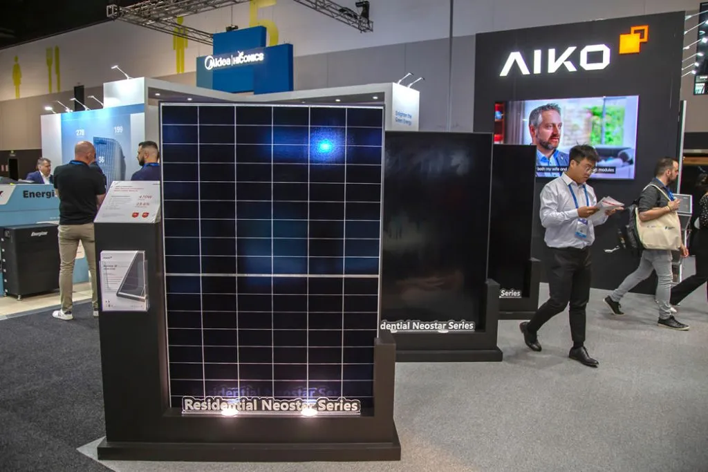 AIKO Neostar solar panel displayed at a clean energy trade show.
