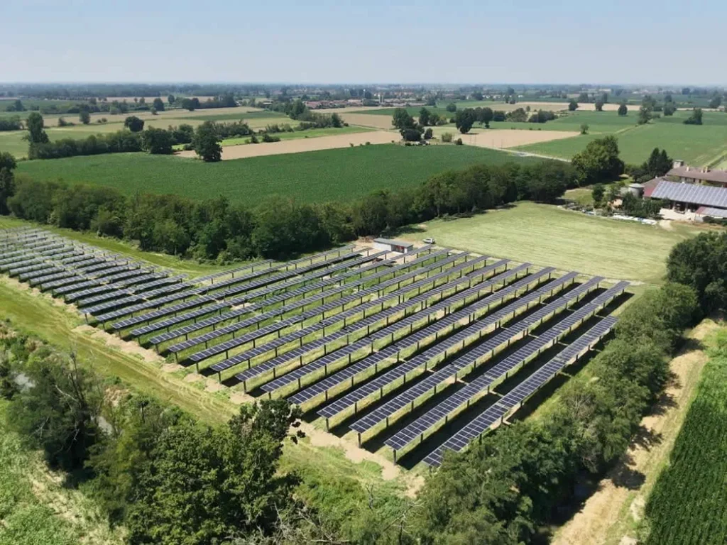 Aerial view of AIKO solar panels installed across a green field.