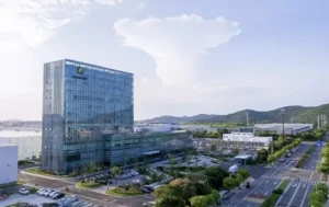 Modern Astronergy office and manufacturing campus with glass building and surrounding roads.