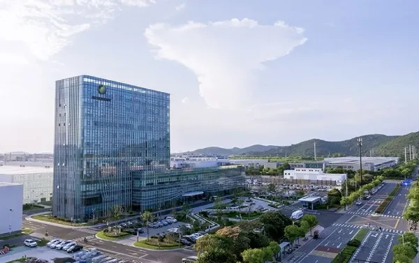 Modern Astronergy office and manufacturing campus with glass building and surrounding roads.