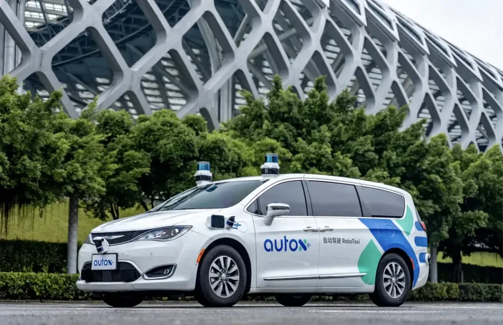 AutoX robot taxi parked near a modern building