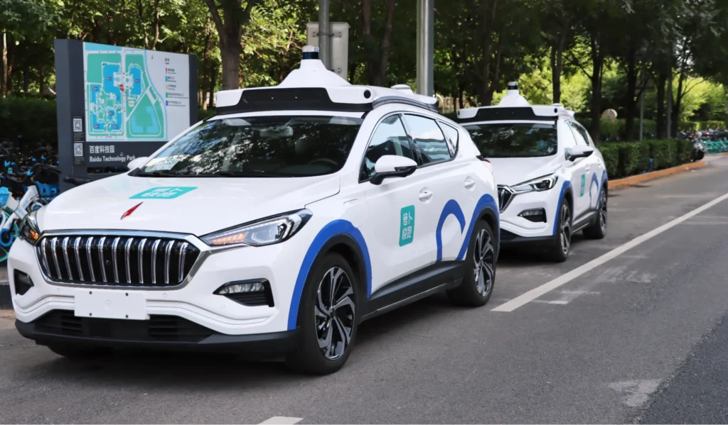 Two Baidu robot taxi vehicles parked on a city road