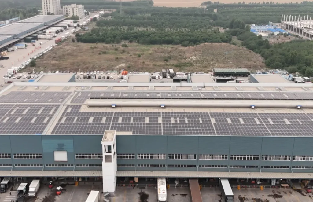 Wide rooftop solar array installed on a large commercial warehouse.