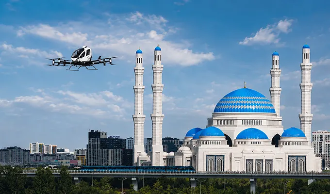 EHang eVTOL flying near a blue domed mosque