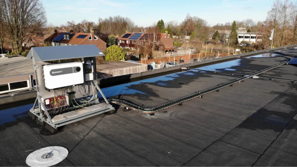 Growatt battery and inverter units installed beside an electrical control wall