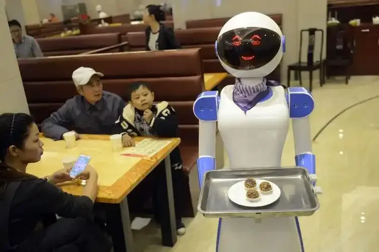 Robot waiter serving diners at a table