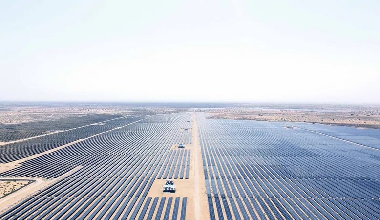 Large solar farm with long rows of panels in a desert area.